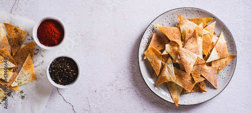 Spicy chips with paprika and dill from tortilla on a plate top view web banner photo