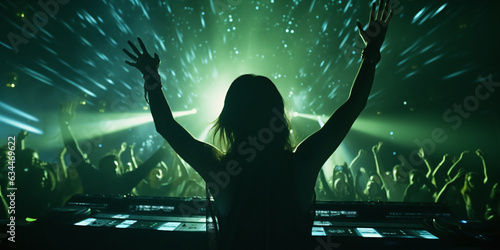 Girl DJ in club and people dancing in electronic music, techno or raving in laser spotlight. Night club crowd dance with hands up in cinematic photography style