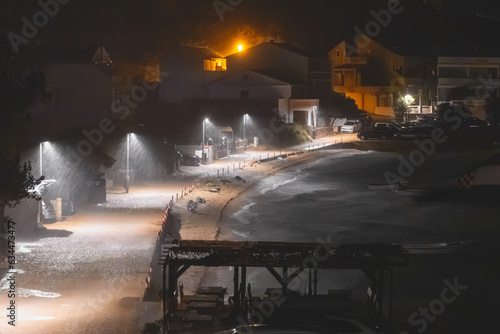 Heavy rain at night on the beach in the resort town. Storm by the sea at night