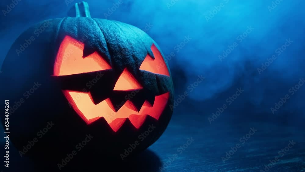 Halloween pumpkin smile and scary eyes with smoke at dark background