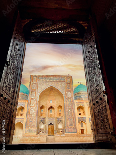 Sunset View to Mir i Arab madrassa thru the old wooden carved door, Bukhara, Uzbekistan photo