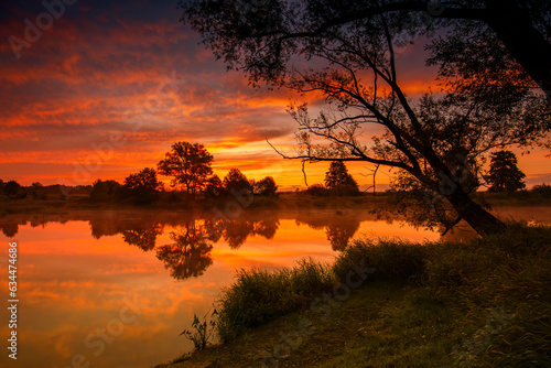 Letni wschód słońca nad rzeka © anettastar