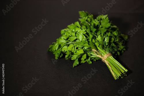 Obraz na płótnie Bunch of green organic parsley on a dark background. Fragrant seasoning for salad or other dishes. Space for text. w salonie