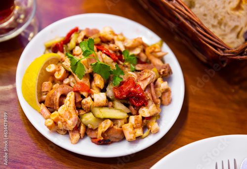 Ahtapot salatasi, traditional turkish octopus salad with vegetables and lemon photo