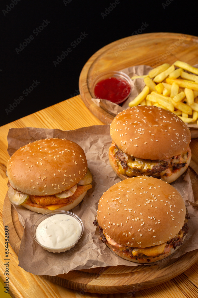 a set of three burgers, two sauces and french fries. Street food. Fast food. Menu for street cafe, fast food restaurant.