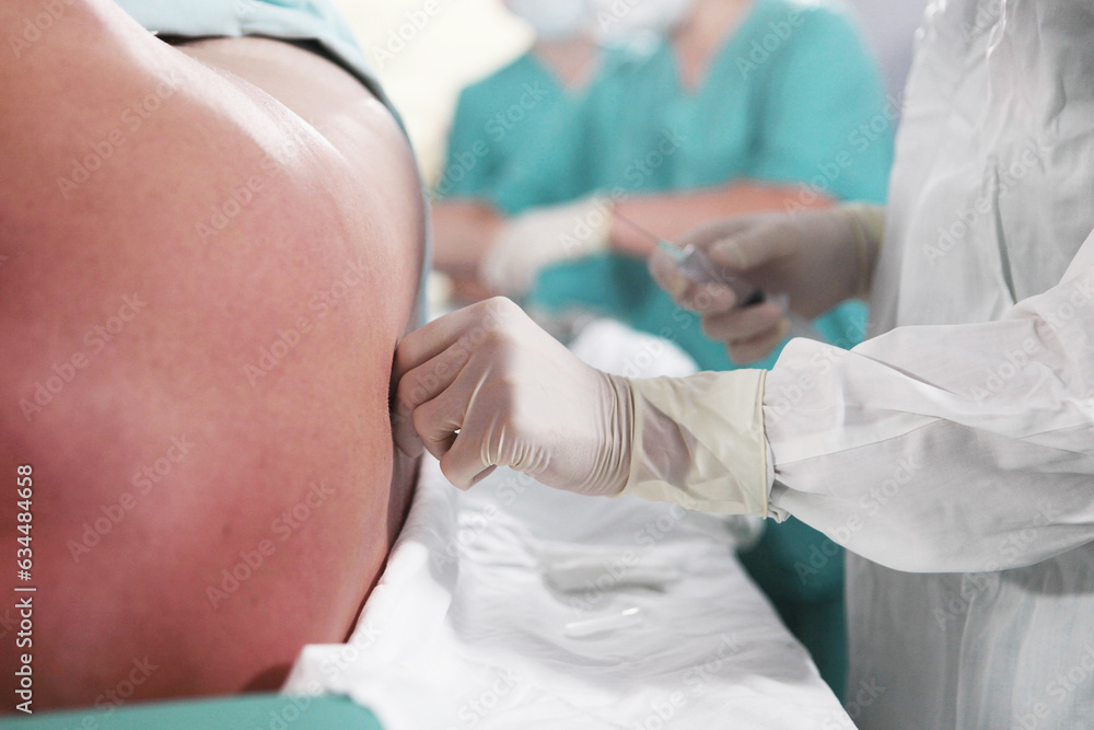 Anesthesiologist performs epidural anesthesia. Injections of spinal anesthesia.Unrecognizable personalities. Anesthesiologist performs epidural anesthesia. Injections of spinal anesthesia.Unrecognizable personalities.