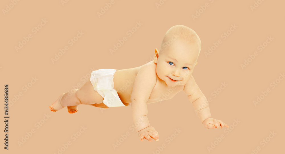 Portrait of cute baby crawling on the floor on brown studio background