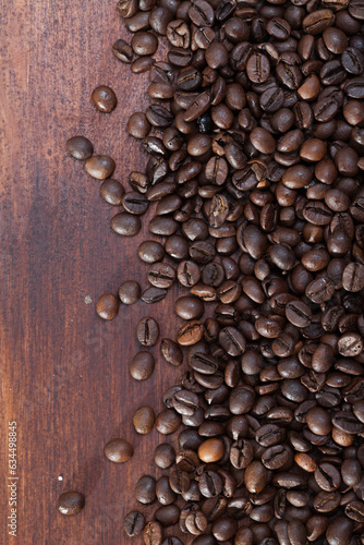 Closeup of roasted coffee beans on dark wooden background..