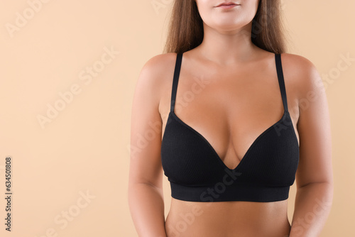 Woman with beautiful breast on beige background, closeup. Space for text