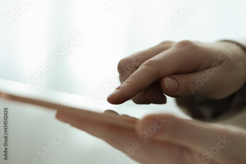 Closeup view of woman using modern tablet on blurred background
