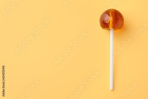 Tasty lollipop on yellow background, top view. Space for text