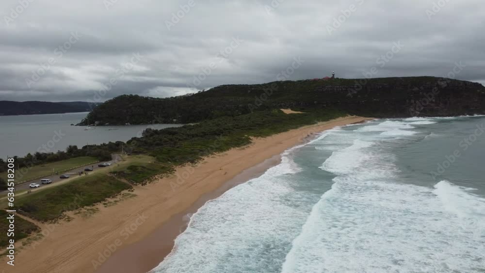 Drone flying over beautiful sandy beach revealing a bay on the other side of the peninsula Drone flying over beautiful sandy beach revealing a bay on the other side of the peninsula