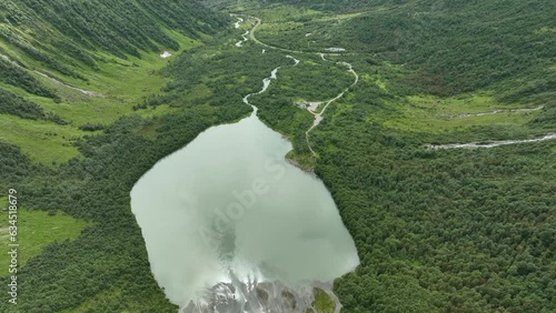 Green lake Brevatnet in Fjaerland Norway - Aerial moving down from Boyabreen glacier glacier towards lush green lake and valley photo