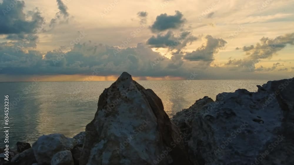 Timelapse of the shoreline rocks in the foreground and the clouds and ocean at dusk near Ambergris Caye or Bay, Belize. Locked wide time lapse shot Timelapse of the shoreline rocks in the foreground and the clouds and ocean at dusk near Ambergris Caye or Bay, Belize. Locked wide time lapse shot