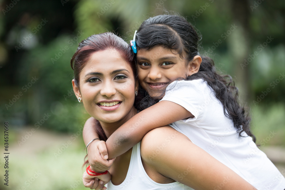 Fototapeta premium Happy Indian mum and her child playing outdoors