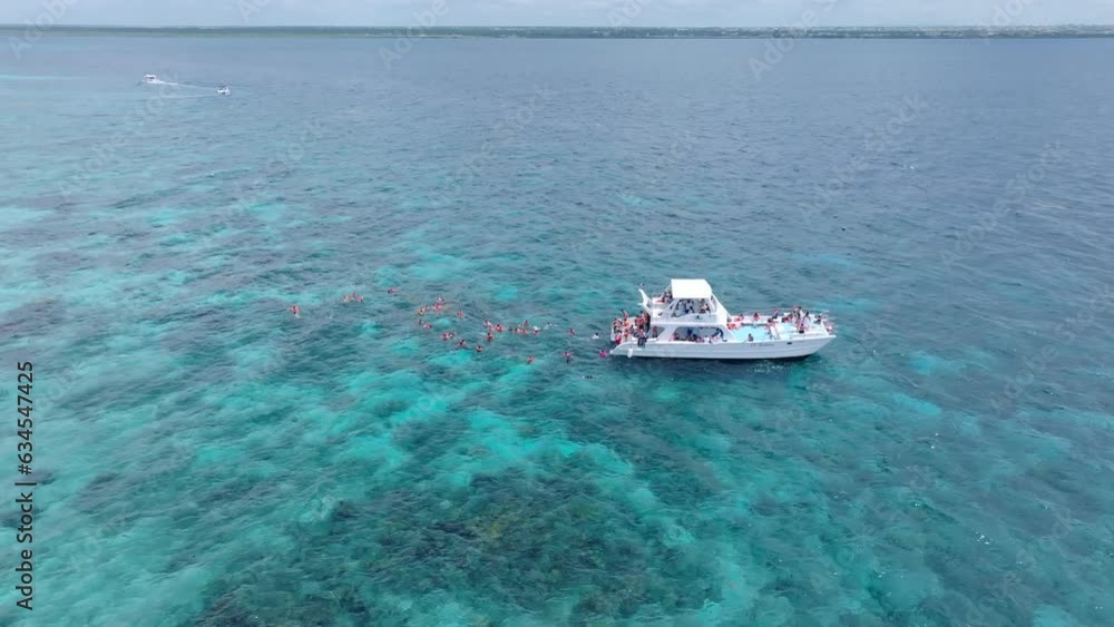 Aerial top down shot showing tourist boat showing group of snorkeler diving underwater on Caribbean sea - orbiting shot Aerial top down shot showing tourist boat showing group of snorkeler diving underwater on Caribbean sea - orbiting shot