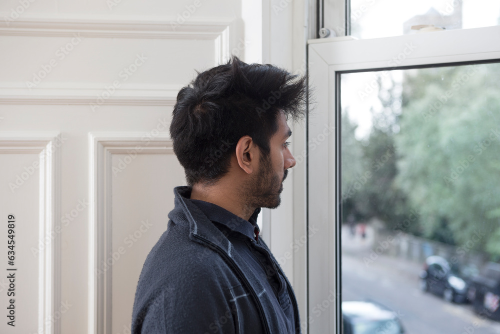 Indian man at home looking out of the window. Indian man at home looking out of the window.
