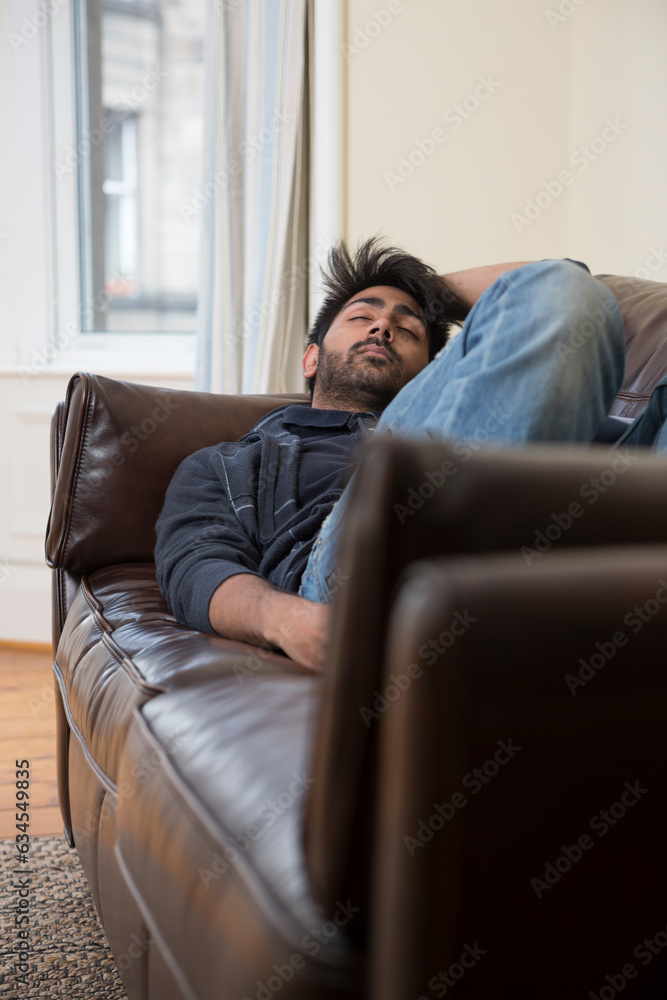 Indian man sleeping on couch at home. Indian man sleeping on couch at home.