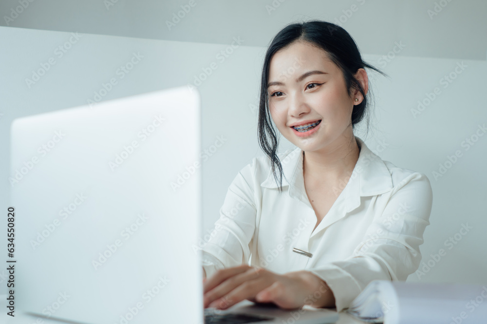 Asian woman rejoicing, say yes, looking happy and celebrating victory, champion dance, fist pump gesture, young happy cheerful cute business woman sitting indoors in office Asian woman rejoicing, say yes, looking happy and celebrating victory, champion dance, fist pump gesture, young happy cheerful cute business woman sitting indoors in office