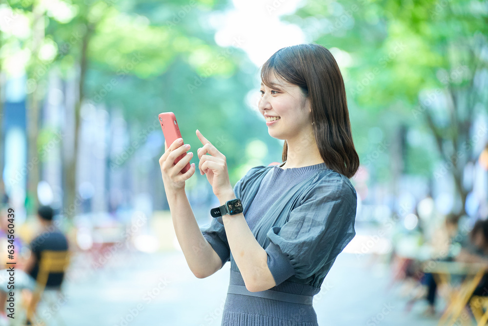 スマートフォンの画面を見る若い女性