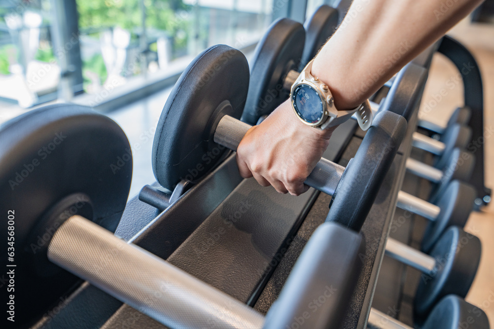 female fitness trainer and determined woman raising dumbbells working out at a gym. Exercise, fitness and healthy lifestyle. female fitness trainer and determined woman raising dumbbells working out at a gym. Exercise, fitness and healthy lifestyle.