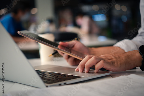 Man or Creative Freelancer working on Laptop and tablet at Office Desk. Business Technology, communication, and global networking Innovation, collaboration, and success in the digital world