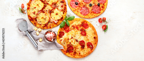 Different types of italian pizza on light background.