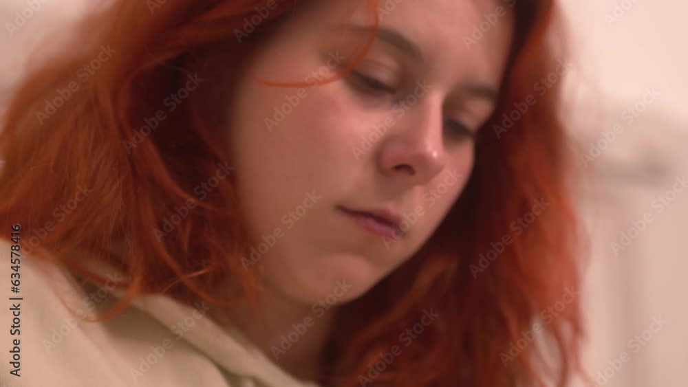 A young red-haired woman journaling before bed A young red-haired woman journaling before bed