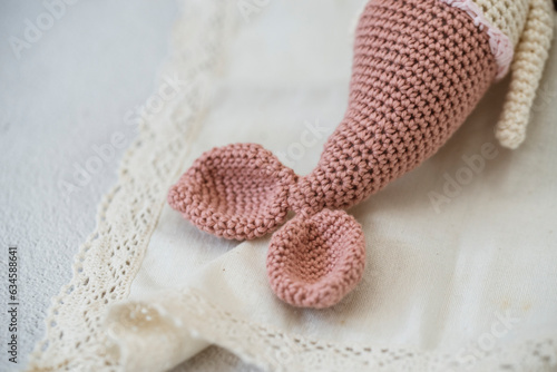 Close-up of a crochet amigurumi mermaid tail on a lace tablecloth photo