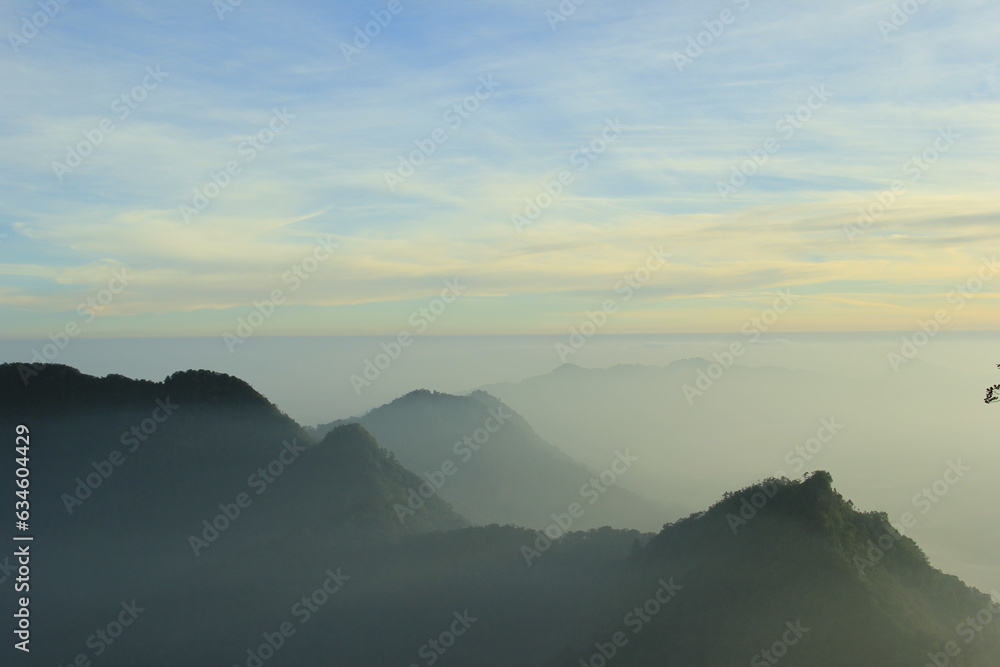 Fototapeta premium Photo illustration of a mountain landscape covered in milky white clouds