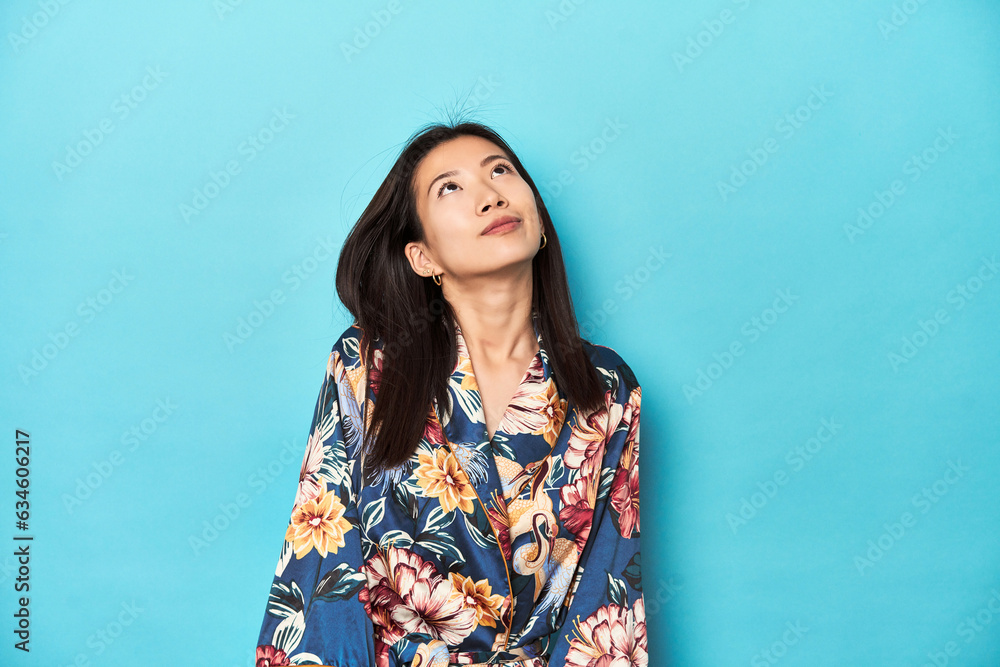 Elegant young Asian woman in kimono, studio shot dreaming of achieving goals and purposes Elegant young Asian woman in kimono, studio shot dreaming of achieving goals and purposes