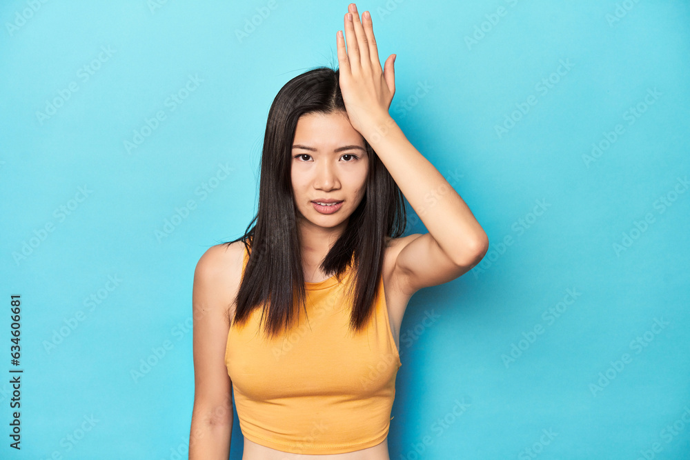 Asian woman in summer yellow top, studio setup, forgetting something, slapping forehead with palm and closing eyes. Asian woman in summer yellow top, studio setup, forgetting something, slapping forehead with palm and closing eyes.
