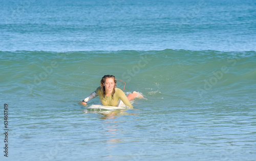 Pretty young woman surfer just before the takeoff of in the ocean waves