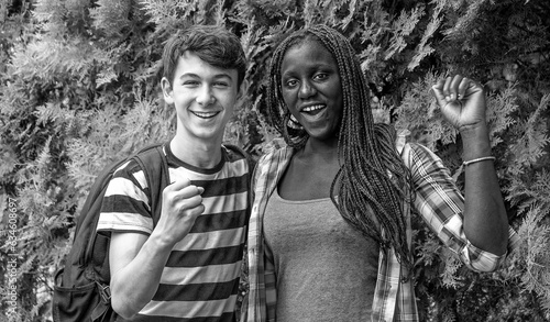 African and caucasian teenagers smiling together outdoor.