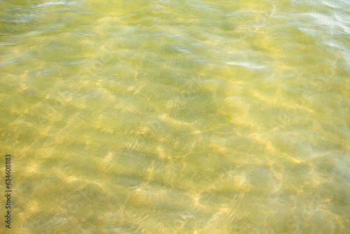 Clean, clear sea water surface in bright sunlight, water texture