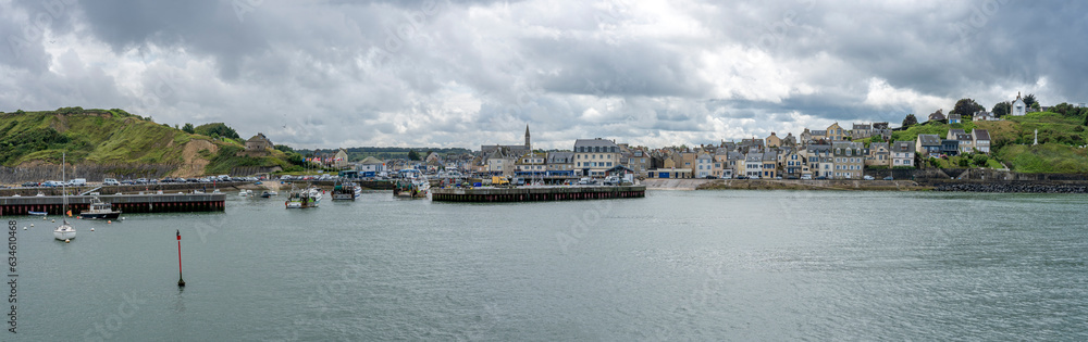 Port-en-Bessin-Huppain, France - 07 24 2023: Panoramic view of the harbor, the pier, boats, the city and the cliff.