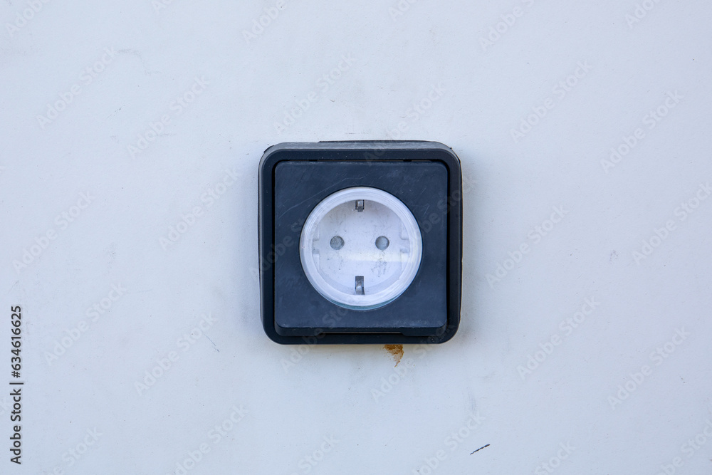 White dirty building facade with outdoor electrical outlet White dirty building facade with outdoor electrical outlet