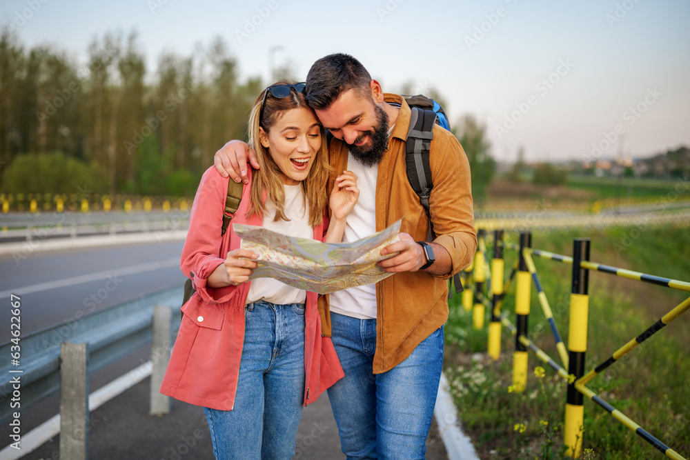 Happy smiling couple are looking at map in the city. Tourists are sightseeing in the city. Happy smiling couple are looking at map in the city. Tourists are sightseeing in the city.
