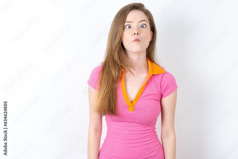 Young woman wearing pink dress making fish face with lips, crazy and comical gesture. Funny expression. Young woman wearing pink dress making fish face with lips, crazy and comical gesture. Funny expression.