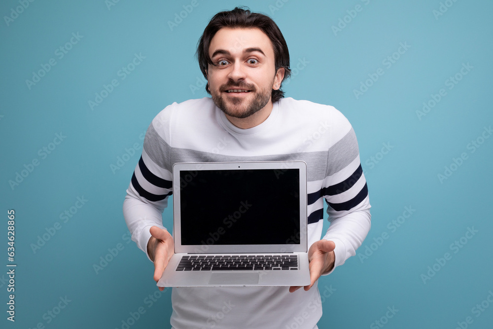 smart european young guy with chic black hair shows promotional offer on blank screen smart european young guy with chic black hair shows promotional offer on blank screen