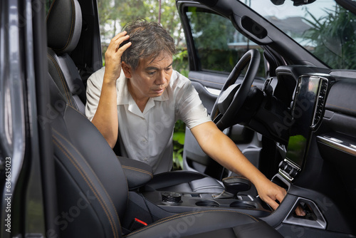 Billede på lærred Senior asian man look for a key inside car.