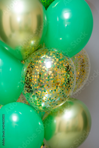 green dinosaur balloon, bundle of green balloons and golden confetti balloons