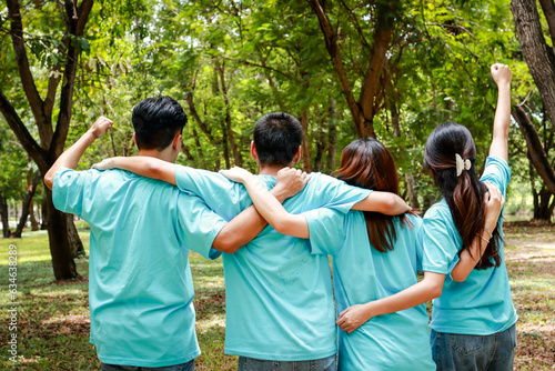 Asian youth volunteer group Hugging, raising arms, gathering power to do good deeds. Volunteer concept. Planting trees does not reduce global warming. save the world