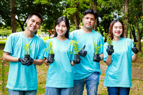 Young Asian volunteers hold saplings to plant a forest. Volunteer concept. Planting trees does not reduce global warming. save the world photo