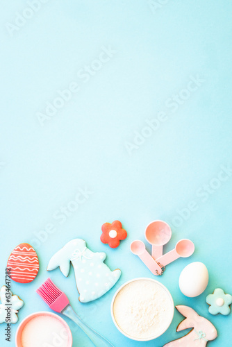 Easter baking, Flour, edds, sugar and gingerbread cookies. Top view on blue. photo