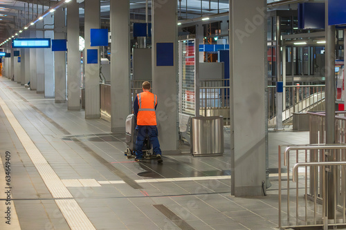 Obraz na płótnie Arbeiter säubert den Boden mit einer Scheuersaugmaschine w salonie