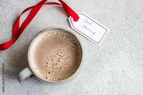 Overhead view of a mug of milky coffee or hot chocolate with a Good Morning tag photo
