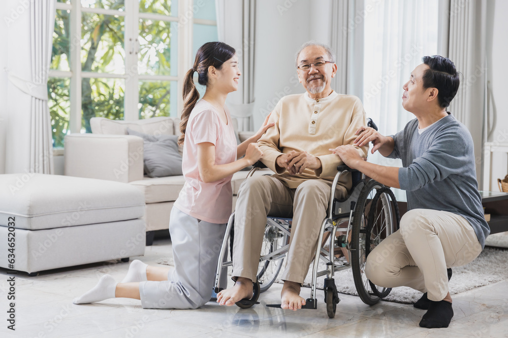 happy Asian family, senior man on wheelchair with daughter and son at home happy Asian family, senior man on wheelchair with daughter and son at home