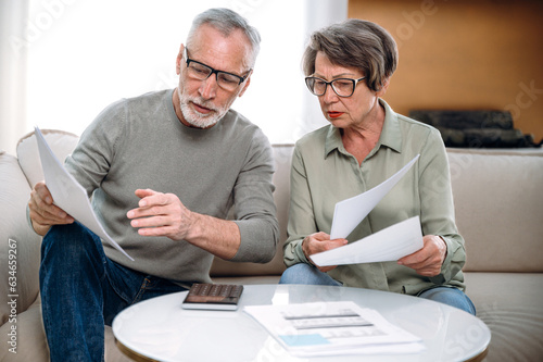 Canvas-taulu mature couple holding current expense document and fill tax form