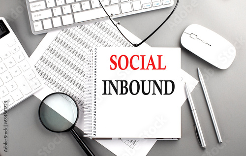 SOCIAL INBOUND text on notepad on chart with keyboard and calculator on grey background photo